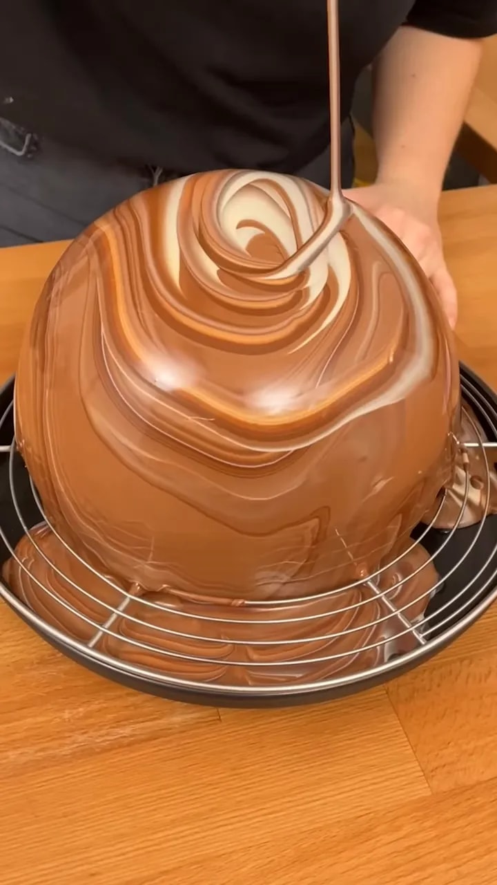 Grande coque en chocolat marbré recouvrant un saladier