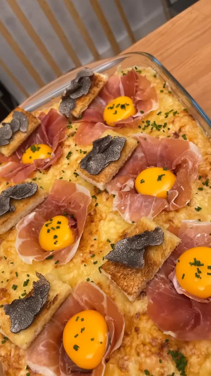 Gratin de pâtes au fromage décoré de jambon cru jaunes d œufs et truffe